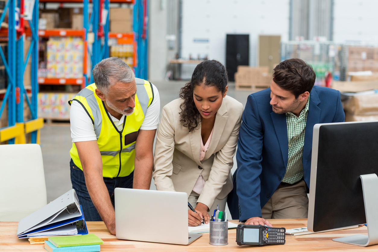 industrial packaging solutions — Warehouse managers and worker discussing with laptop