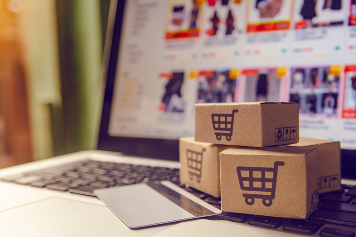 eCommerce packaging — Shopping online concept - Shopping service on The online web. with payment by credit card and offers home delivery. parcel or Paper cartons with a shopping cart logo on a laptop keyboard