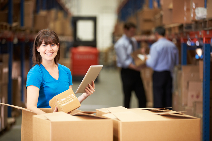 environmentally friendly packaging — Woman in warehouse with boxes and digital tablet
