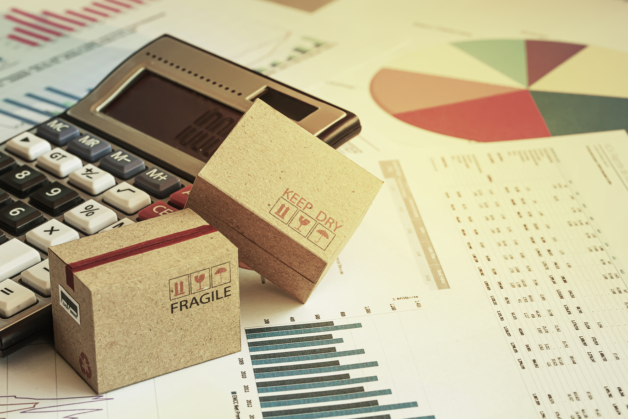 packaging cost reduction — Packaging boxes with calculator and this type of financial charts include stacks of bar compare between the expansion of export business and increase the rate of goods each year.